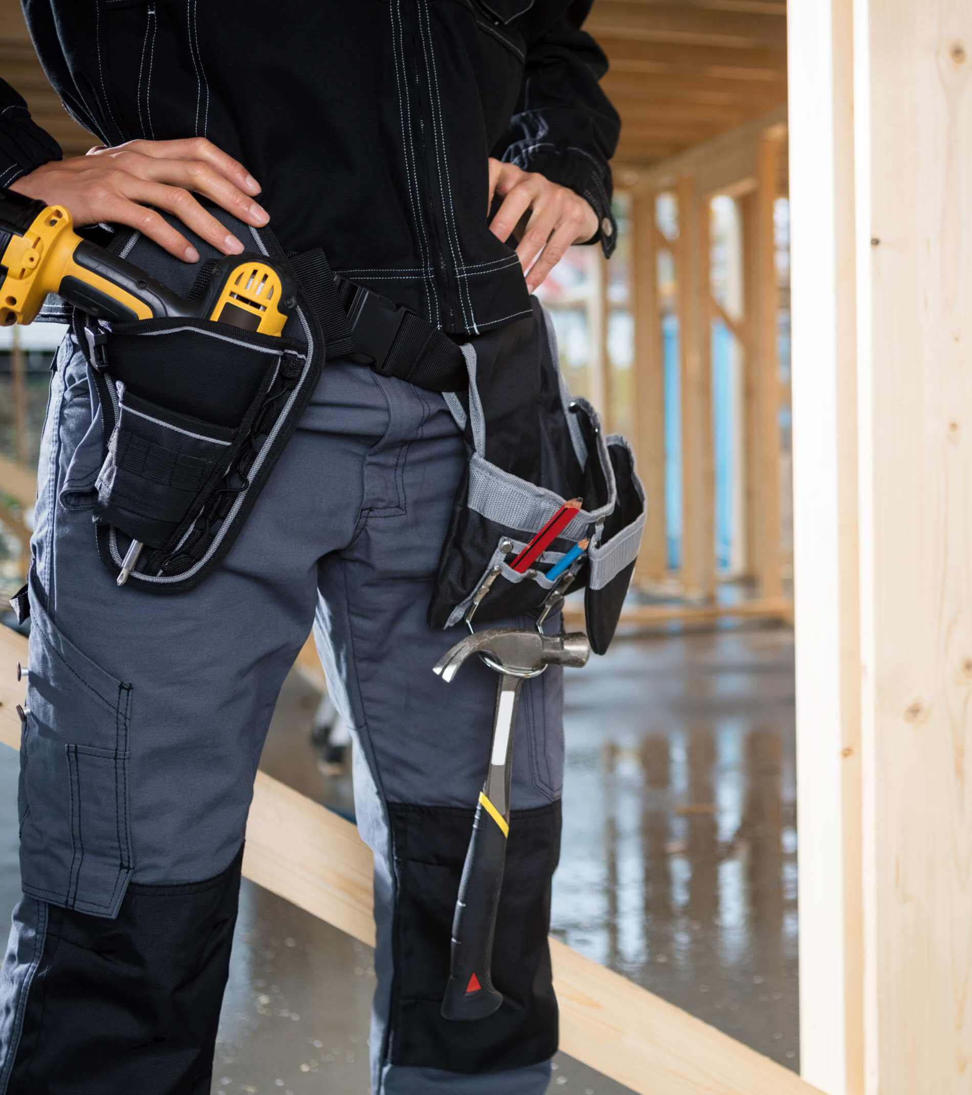 Midsection Of Carpenter Standing With Hands On Hips At Site